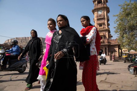 Foto de A group of women dressed in full-cover dress cross the Clocktower square in the markets of Jodhpur's old town - Imagen libre de derechos