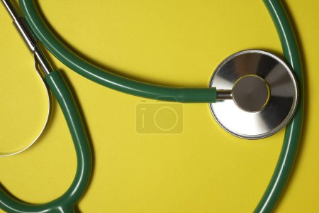 Foto de Stethoscope on a yellow table - Imagen libre de derechos