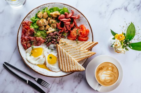petit déjeuner anglais avec ?ufs brouillés, bacon, haricots, champignons et café sur une table en marbre