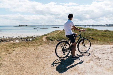 Photo for Attractive young male riding bicycle in the Island of Batz - Royalty Free Image