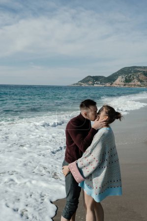 Téléchargez les photos : Couple baisers sur le fond de la mer et des montagnes - en image libre de droit