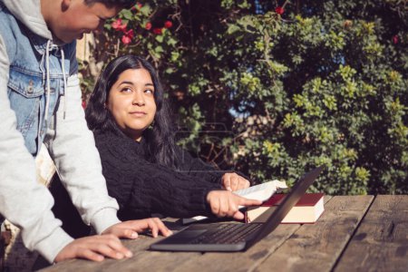Téléchargez les photos : Deux jeunes étudient en dehors de l'école avec ordinateur portable - en image libre de droit
