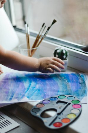 Téléchargez les photos : Main d'enfant pour dessiner avec des peintures - en image libre de droit