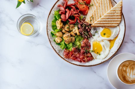 Téléchargez les photos : Petit déjeuner anglais avec œufs brouillés, bacon, haricots, champignons et café sur une table en marbre - en image libre de droit