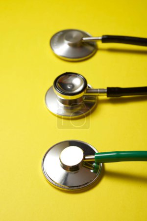 Photo for Three stethoscopes on a yellow table - Royalty Free Image
