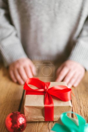 Foto de Mujer envolviendo regalos de Navidad sobre fondo de madera - Imagen libre de derechos