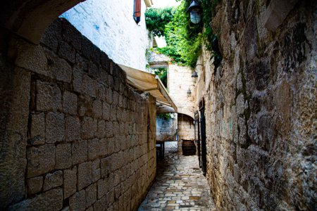 Photo for Medieval alley of large stones and background bar - Royalty Free Image