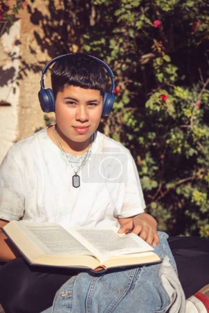 Téléchargez les photos : Jeune étudiant lisant dans le jardin à la maison - en image libre de droit