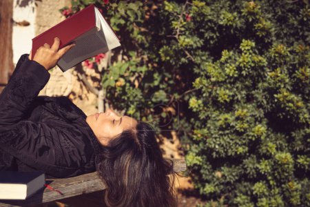 Téléchargez les photos : Femme tenant un livre ouvert dans le jardin - en image libre de droit