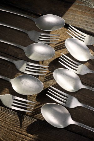 Téléchargez les photos : Fourchettes et cuillères alignées sur une table en bois - en image libre de droit