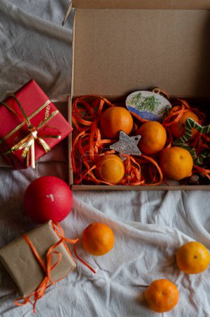 Téléchargez les photos : Mandarines dans un coffret cadeau avec décorations de Noël - en image libre de droit