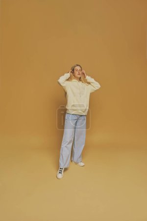 Photo for Young freckles woman wearing a yellow sweatshirt - Royalty Free Image