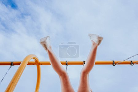 Photo for Feet of child swinging at a playground - Royalty Free Image