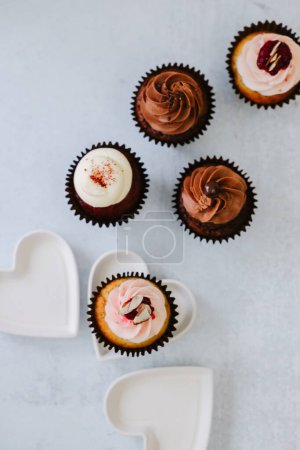 Photo for Delicious Chocolate, red velvet, raspberry cupcakes with white hearts - Royalty Free Image