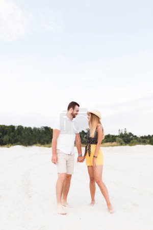 Téléchargez les photos : Man and woman holding hands on sandy beach in summer - en image libre de droit