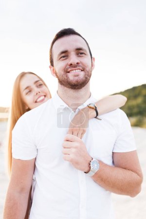 Téléchargez les photos : Man and a woman are hugging on a sandy beach in summer - en image libre de droit