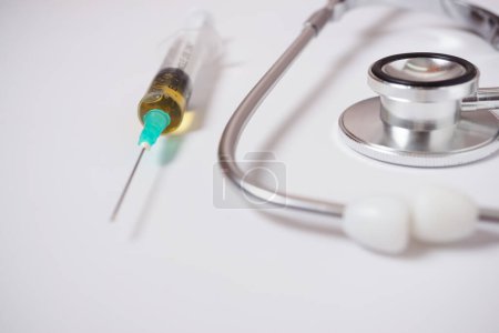 Photo for Syringe with medicine on a stethoscope isolated on a white background - Royalty Free Image