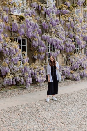 Photo for Brunette girl in front of wall of wisteria in neutral outfit - Royalty Free Image