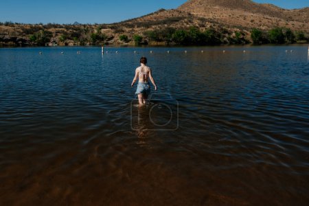 Foto de Adolescente chica caminando en un lago en un día soleado - Imagen libre de derechos