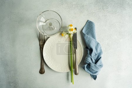 Téléchargez les photos : Spring table setting with daffodil flowers on concrete background - en image libre de droit