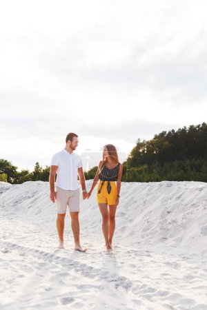 Téléchargez les photos : Homme et une femme marchent sur une plage de sable chaud en été - en image libre de droit