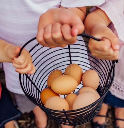 kids holding a basket of eggs