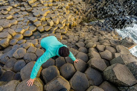 Téléchargez les photos : Une femme marche sur une formation rocheuse unique en Irlande - en image libre de droit