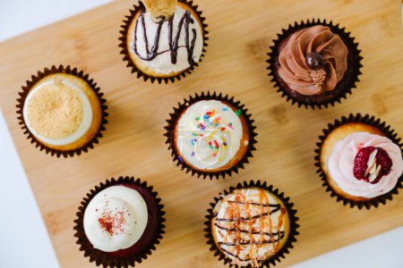 Photo for Birthday cupcake assortment on wood cutting board - Royalty Free Image