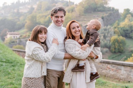 Téléchargez les photos : Une famille heureuse avec deux enfants dans un point de vue de Bergame, Italie - en image libre de droit