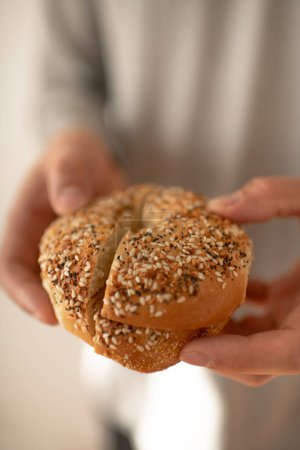 Téléchargez les photos : Personne tenant un bagel tout à manger pour le petit déjeuner - en image libre de droit