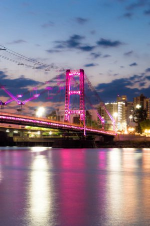 Photo for Suspension bridge illuminated with pink LED lights. - Royalty Free Image