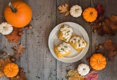 Photo for Overhead view of pumpkin scones on a plate on wooden table. - Royalty Free Image