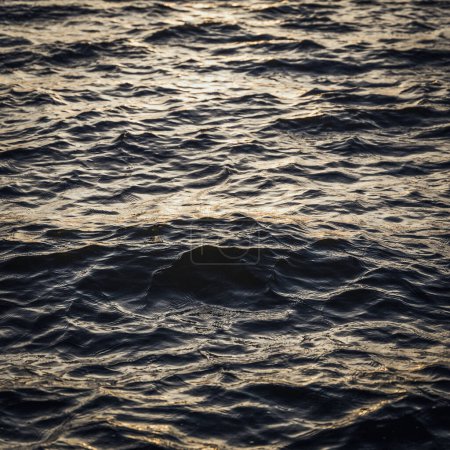 Photo for Close up view on water surfaces with waves and ripples and the sunset - Royalty Free Image