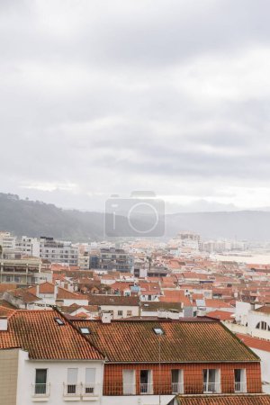 Foto de Vista superior de las calles con casas blancas y techos de azulejos anaranjados, una antigua ciudad portuguesa en el océano. Nazare, Portugal - Imagen libre de derechos