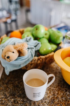 Colorful cluttered kitchen counter with coffee and fruit
