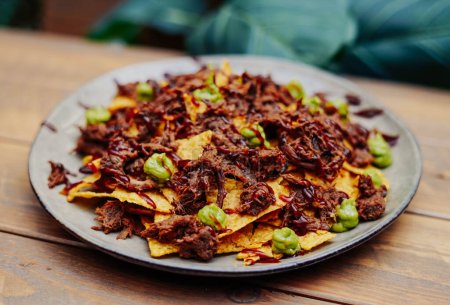 Photo for Mexican nachos with beef and chilli on wooden table - Royalty Free Image