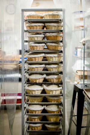 Photo for Trays of bread dough in cloth-lined basket in commercial kitchen - Royalty Free Image