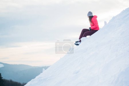 Foto de Mujer sentada en la nieve en la montaña - Imagen libre de derechos
