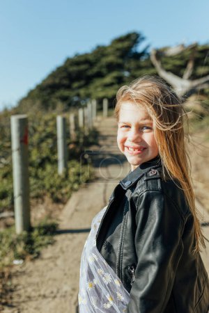 Foto de Chica joven sonriendo en un día soleado y ventoso - Imagen libre de derechos