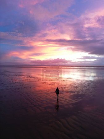 Foto de Chica caminando en una playa en el oeste de Inglaterra al atardecer avión no tripulado aéreo - Imagen libre de derechos