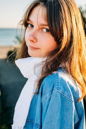 Téléchargez les photos : Portrait d'une jolie fille aux cheveux longs sur la plage gros plan - en image libre de droit