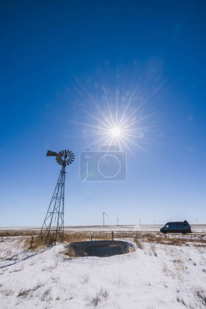 Téléchargez les photos : Vieux et nouveaux moulins à vent avec une fourgonnette garée par une journée ensoleillée d'hiver, Kansas - en image libre de droit