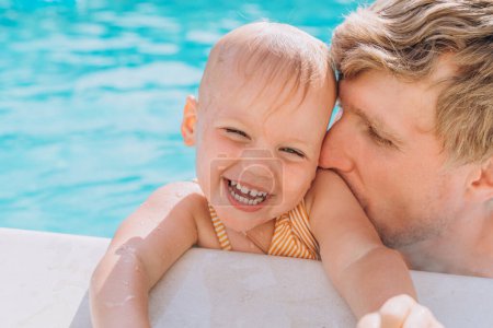 Téléchargez les photos : Père et filles jouant dans la piscine extérieure - en image libre de droit