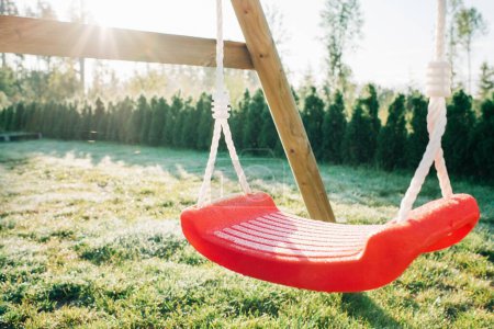 Photo for Childs swing in a garden covered in frost in the morning sunshine - Royalty Free Image