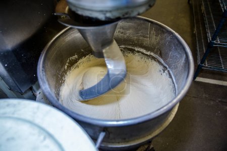 Téléchargez les photos : Vue de dessus de pâte à pain étant mélangé dans une cuisine commerciale - en image libre de droit
