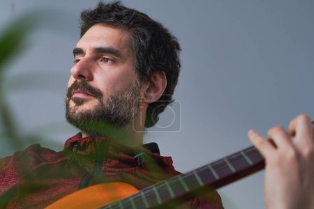 Foto de Joven barbudo tocando la guitarra española - Imagen libre de derechos