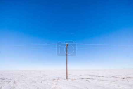 Téléchargez les photos : Un poteau électrique dans une scène hivernale minimale sur un prarie plat, Kansas - en image libre de droit