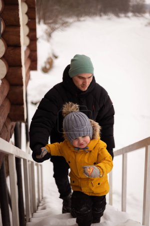 Téléchargez les photos : Papa et fils monter les escaliers en hiver en plein air - en image libre de droit