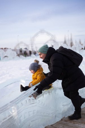 Téléchargez les photos : Père et fils en hiver sur un toboggan - en image libre de droit