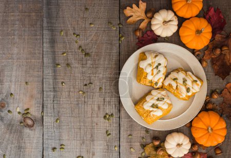 Photo for Overhead view of pumpkin scones on a plate on wooden table. - Royalty Free Image